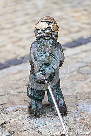 Wroclaw dwarf, small fairy-tale bronze figurine on the side walk, Wroclaw, Poland Editorial Stock Photo