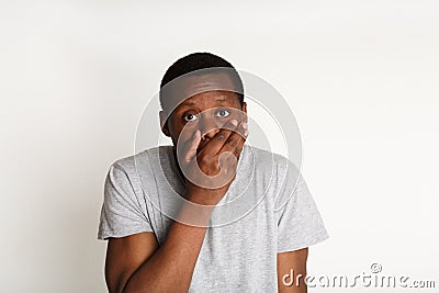 Wrong answer, confused black man covering mouth with hand Stock Photo