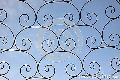 Wrought iron fence on a blue background. Stock Photo