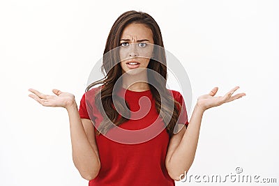 Wtf going on explain. Intense frustrated and shocked young brunette woman, raising hands up make shoulder shrug Stock Photo