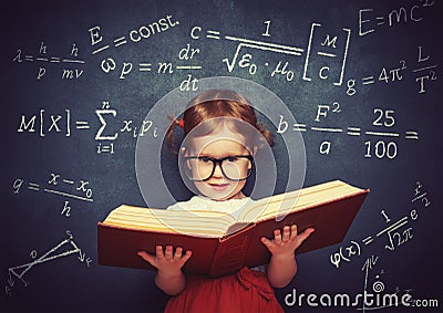 wunderkind little girl schoolgirl with a book from the blackboard with physical formulas Stock Photo