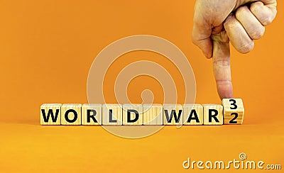 WW3 world war 3 symbol. Businessman turns the wooden cube and changes the concept word World War 2 to World War 3. Beautiful Stock Photo