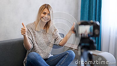 Wwoman or blogger with camera recording video and showing thumbs up Stock Photo