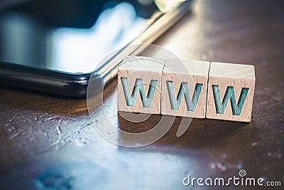 WWW Written On Wooden Blocks Next To A Smartphone On A Table Stock Photo