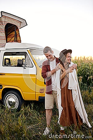 It& x27;s getting cold. Smiling relaxed happy Hippie couple on trip in countryside. Stock Photo