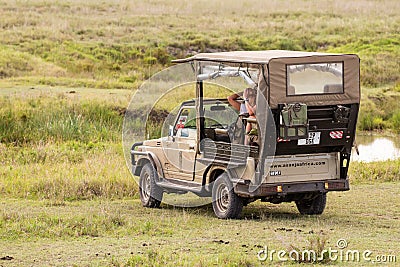 4x4 vehicle on african safari game drive with tourists watching wild animals Editorial Stock Photo