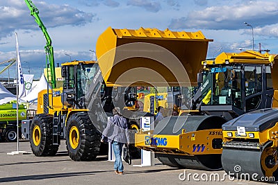 XCMG stand at the construction fair Bauma CTT Russia. Heavy front loader LW700KN with bucket and asphalt rollers at the Editorial Stock Photo