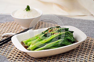 XIAO BAI CAI With GARLIC OYSTER SAUCE with chopsticks served in dish isolated on table top view of singapore food Stock Photo