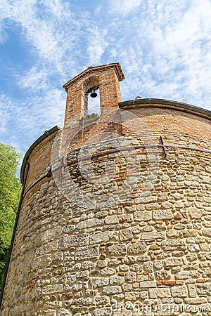 XIII century baptistery church with brick wall and small bell Stock Photo