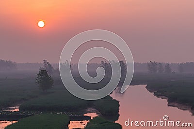 XINGHUA, CHINA: Canal in rapeseed field at morning Stock Photo
