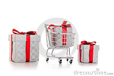 Xmas gift. Trolley cart for supermarket with christmas or birthday gift box isolated on white background. Creative idea for Stock Photo