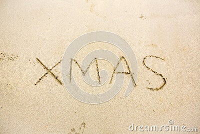 xmas hand writing on sand beach. christmas sign on natural brown background.celebrate christmas festival with the natural is conce Stock Photo