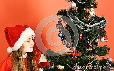 Xmas holiday concept. Miss Santa stands by Christmas tree. Stock Photo