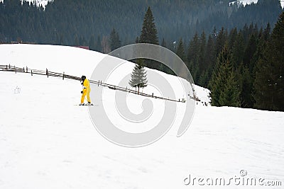 Yablunytsya, Ukraine February 2, 2019: woman in a yellow suit goes skiing, tourists of Ukraine in the village of Yablunytsya Editorial Stock Photo