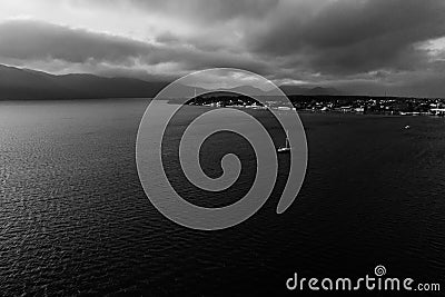 Yacht heading ashore. Dramatic black and white photo. Stock Photo