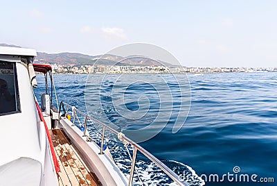 Yacht or private luxury boat ride. Sailing in the sea or ocean with motorboat or sailboat. View from the deck to the coast. Stock Photo