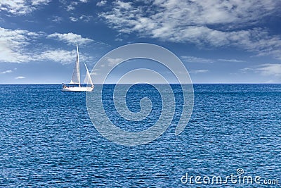 Yacht sailboat. Yacht sailboat sailing alone on calm blue sea waters on a beautiful sunny day with blue sky and white clouds Stock Photo