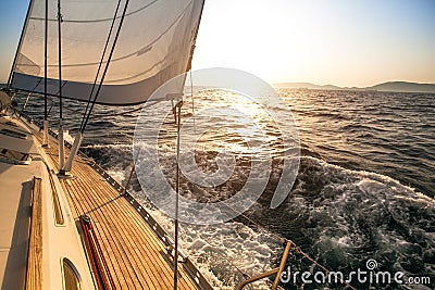 Yacht sailing towards the sunset Stock Photo