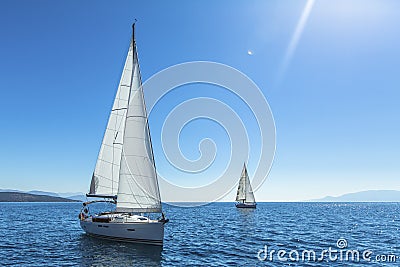 Yachting. Tourism. Luxury Lifestyle. Ship yachts with white sails in the open sea. Stock Photo