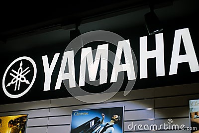 Yamaha music brand logo on black wall with musicians photo Editorial Stock Photo