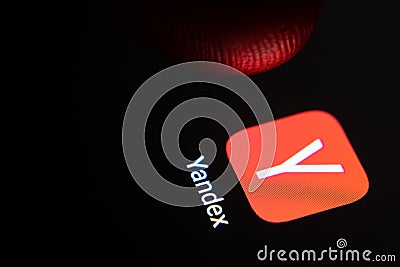 Yandex app and finger launching it. Macro photo Editorial Stock Photo