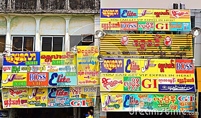 Yangon, Myanma - March 9, 2015: Full of adverts wall in Yangon Myanma Editorial Stock Photo