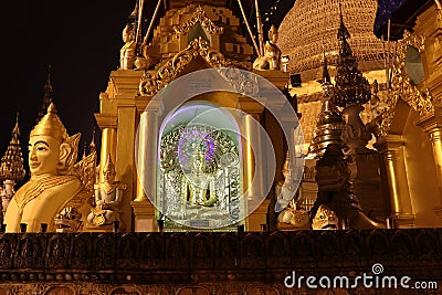 Night shot of stucco buddha statue decorated in golden be enshrined inside the arch at Shwedagon Pagoda, Yangon Myanmar Editorial Stock Photo