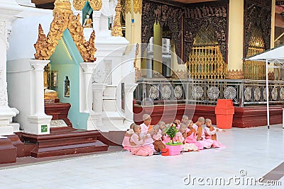 Group of burmese nuns sitting and praying in front of Shwedagon pagoda 1 of 5 sacred places Editorial Stock Photo