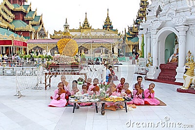 Group of burmese nuns sitting and praying in front of Shwedagon pagoda 1 of 5 sacred places Editorial Stock Photo