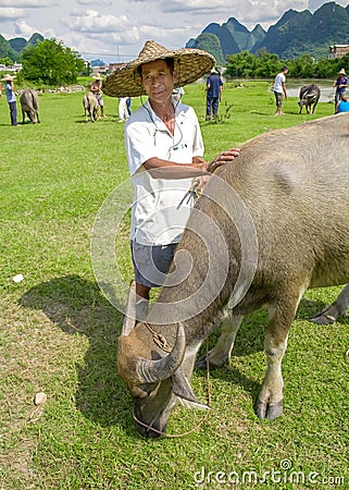 Local chinese farmer with water buffalo. Beautiful landscape in Yangshuo, Guangxi, China. Editorial Stock Photo