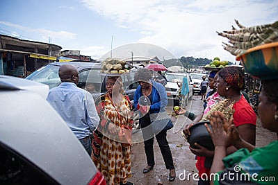 African female hawker with with baskets of food on their heads sell their products on the Editorial Stock Photo