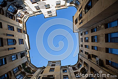 The yard is a well in St. Petersburg. Bottom view. Stone walls going up. The central part of St. Petersburg. Windows, downpipes, Editorial Stock Photo