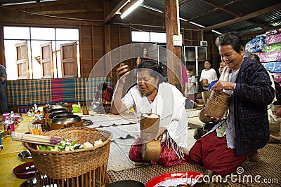 Thai people put food offerings of tradition of almsgiving with sticky rice and food to Buddhist alms bowl at Retro house on Editorial Stock Photo