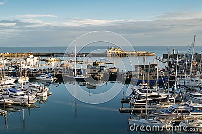 Yatchs moored in Ramsgate Royal Harbour. The harbour lock gates, the end of pier restaurant and lighthouse can also be seen Editorial Stock Photo