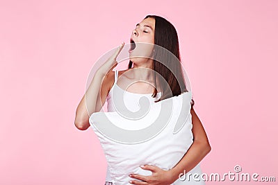 Yawning girl holding pillow Stock Photo