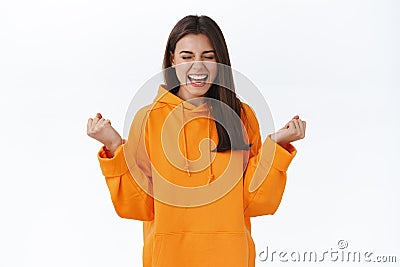Yeah I did it, happy and relieved young successful girl, winning prize, achieve reward, clench fists and scream cheerful Stock Photo