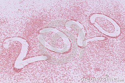 Year 2020 date made of trace of a finger on pink sand Stock Photo