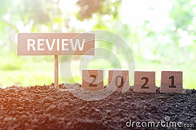 Year end 2021 review and summary concept. Wooden blocks in dark sunset background. Stock Photo