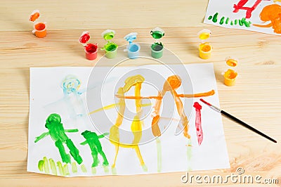 3 year kids drawing happy family picture on the wooden table. To Stock Photo