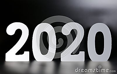 Year 2020 made from wooden white numbers on a black background Stock Photo