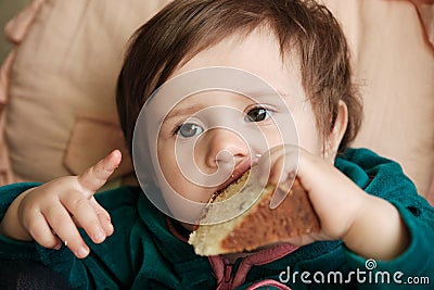 1 year old baby old baby girl eats Panettone. Cute little caucasian girl holding Easter cake Stock Photo