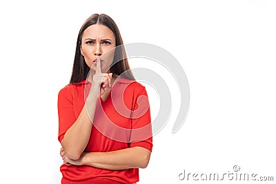 30 year old cunning caucasian woman with straight dark hair dressed in a red short sleeve shirt keeps a secret Stock Photo