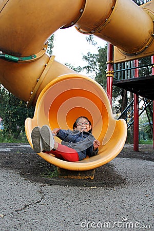 4 year old Latina brunette girl plays in the playground as therapy for Attention Deficit Hyperactivity Disorder ADHD Stock Photo