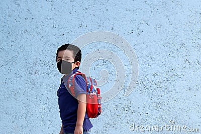 6-year-old Latino boy with covid-19 protective mouthguards, back to school with new normality Stock Photo