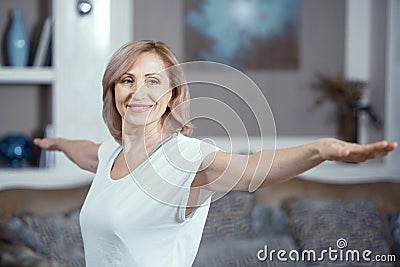 A 50 Year Old Woman Practices Yoga at Home in the Living Room. Stock Photo
