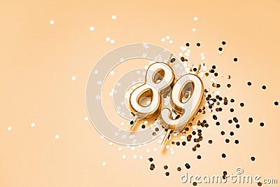 89 years celebration festive background made with golden candles in the form of number Eighty-nine lying on sparkles Stock Photo