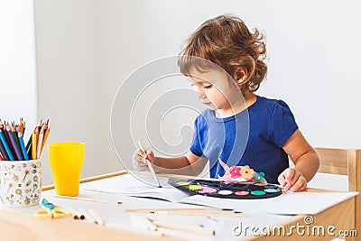 3 years girl painting at the small table at home. Stock Photo