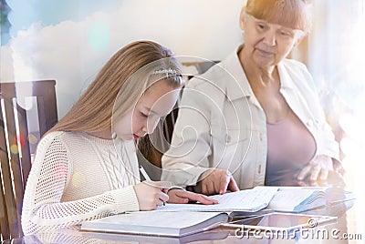 10 years old girl and her teacher. Little girl study during her private lesson. Tutorial and educational concept. Stock Photo