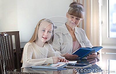 10 years old girl and her teacher. Little girl study during her private lesson. Tutorial and educational concept. Stock Photo