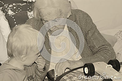90 years old great-grandmother is spending time with her two years old great-grandson Stock Photo